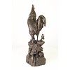 Een bronzen beeld van een haan, moederkip en kuikens