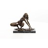 An erotic bronze sculpture of a female nude crouching