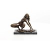 Een erotisch bronzen beeld van een naakte dame in hurkende positie