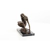 Een erotisch bronzen beeld van een naakte dame in hurkende positie