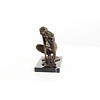 An erotic bronze sculpture of a female nude crouching