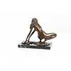 An erotic bronze sculpture of a female nude crouching