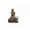 Een bronzen beeld van een zittende art deco danseres