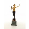 Een bronzen beeld van een halfnaakte danseres ingelegd met hout