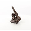 An erotic bronze sculpture of a nude female pleasing herself while lying down