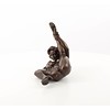 An erotic bronze sculpture of a nude female pleasing herself while lying down