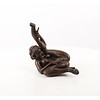 An erotic bronze sculpture of a nude female pleasing herself while lying down