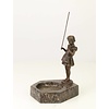 Een marmeren asbak met een bronzen beeld van een vissend meisje