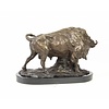 A bronze sculpture of a standing buffalo