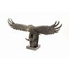 A large bronze sculpture of a descending eagle