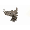 A large bronze sculpture of a descending eagle