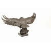 Een groot bronzen beeld van een landende adelaar