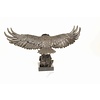 A large bronze sculpture of a descending eagle