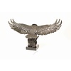 A large bronze sculpture of a descending eagle