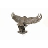 A large bronze sculpture of a descending eagle