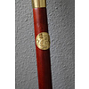 A wooden walking stick with bronze grip of intense female nude