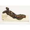 A bronze sculpture of a resting nude lady