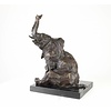 A  bronze sculpture of a sitting elephant