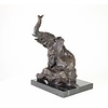 A  bronze sculpture of a sitting elephant