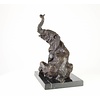 A  bronze sculpture of a sitting elephant