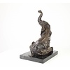 A  bronze sculpture of a sitting elephant