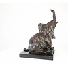 A  bronze sculpture of a sitting elephant