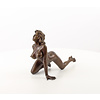 A bronze sculpture of a female nude crawling