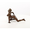 A bronze sculpture of a female nude crawling