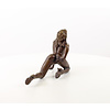 A bronze sculpture of a female nude crawling