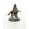 A bronze sculpture of a seated nude female