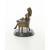 A bronze sculpture of a seated nude female