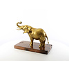 A bronze sculpture of an elephant on a wooden base