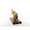 A bronze sculpture of an elephant on a wooden base