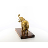 Een bronzen beeld van een olifant op een houten sokkel