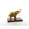 A bronze sculpture of an elephant on a wooden base