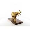 A bronze sculpture of an elephant on a wooden base