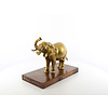 A bronze sculpture of an elephant on a wooden base