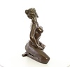 A bronze sculpture of a kneeling female nude