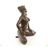 A bronze sculpture of a kneeling female nude