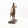 Een bronzen beeld van de godin Diana met hond
