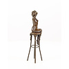 A bronze sculpture of a female nude seated on a barstool