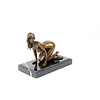 Een bronzen scultpuur van een knielend vrouwlijk naakt
