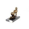 Een bronzen scultpuur van een knielend vrouwlijk naakt