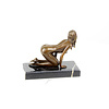 A bronze sculpture of a kneeling female nude