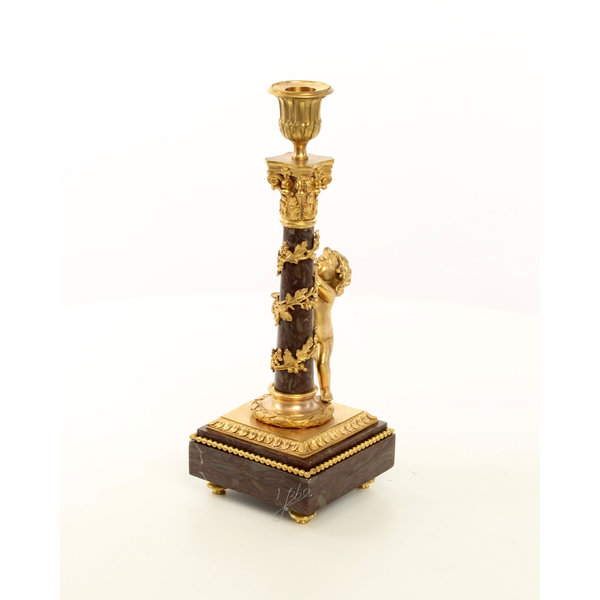  A pair of gilt bronze candlesticks with cherub