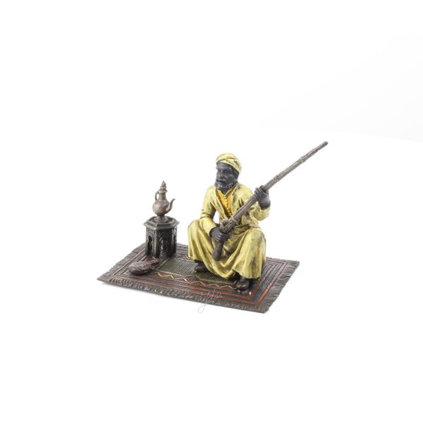  A bronze sculpture of an Arab tribesman on a carpet