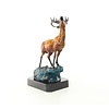 A bronze sculpture of a roaring stag on a rock