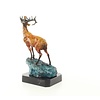 A bronze sculpture of a roaring stag on a rock