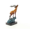 A bronze sculpture of a roaring stag on a rock