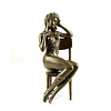 A bronze sculpture of an enticing female seated on a chair